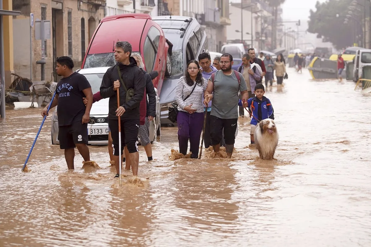 Personas caminando por una calle inundada tras una DANA